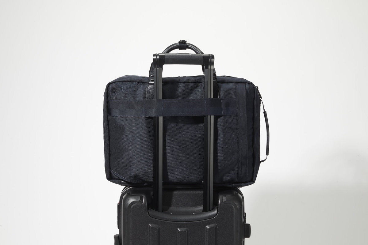トートバッグ背面には、キャリーケースのハンドル部分に連結可能な面ファスナーを採用。出張の際に便利な機能性を備える。