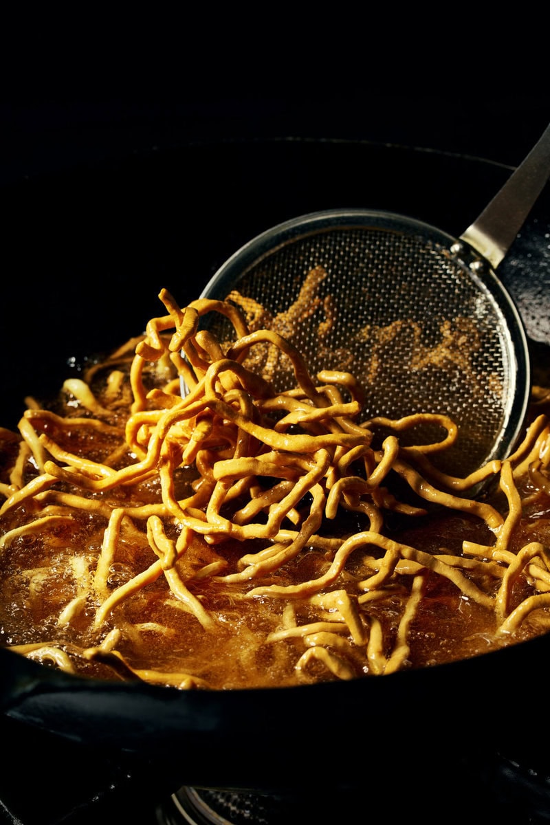 数種類の小麦粉を使い、スナックとして食すのに最適な配合で自家製麺を作成。この麺をさらに“三度揚げ”し、 ラーメンの具材を真空フライすることで、 ガリッとジュワッとした食感を叶えている。