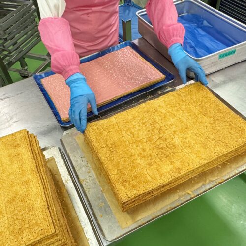焼きあがったパイ生地に濃厚なクリームを重ねていく作業