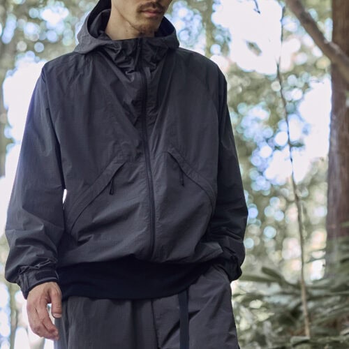 Goldwinのインラインモデル「Hooded Jacket」をベースに、従来の染色方法に比べて水の使用量や化学薬品の使用量を大幅に削減するドープダイを採用したリップストップナイロン素材を採用。都会にも自然にも溶け込むカーボングレーが、アーバンアウトドアなムードをより一層高めてくれる。