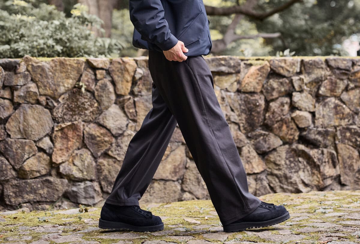 Goldwinらしいミニマルなデザインで、機能性と利便性に優れたワイドトラウザー「25SS別注 Dry Stretch Twill Tuck Pants」が、25FW仕様で新たに展開。今季はウエストに従来のスピンドル仕様を残しつつベルトループを追加したベルト対応で、きれいめな要素をプラス。
