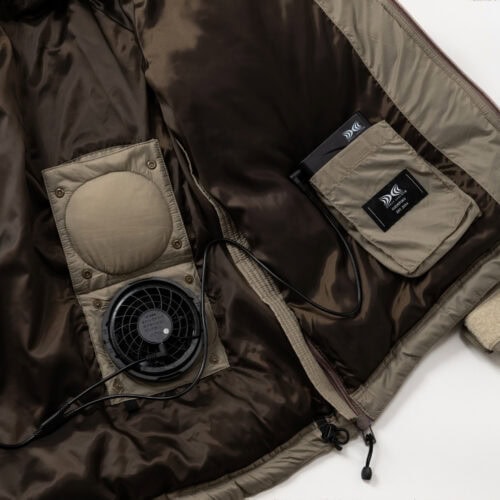 空調服の冷却システムを装備させつつも、ファンを外した状態でも通常のダウンジャケットとしても着⽤できるよう、ファン⽤の⽳を隠す機能を備えている。