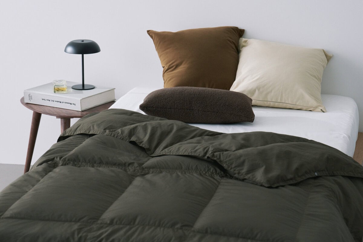 TAIONが提案する新コンセプト「ルームダウン」は、布団・ポンチョ・カーディガンの3WAY仕様に加え、クッションに収納可能。1枚で“掛ける・羽織る・包む・しまう”が完結する、新しい掛け布団の在り方だ。