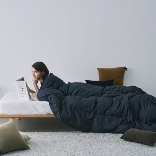 布団としては軽くてあたたかく、羽織ればポンチョやカーディガンのように使える自由な設計。テレビを見ながら、食事をしながら、ゲームをしながら──どんな時間も、ルームダウンに包まれる。