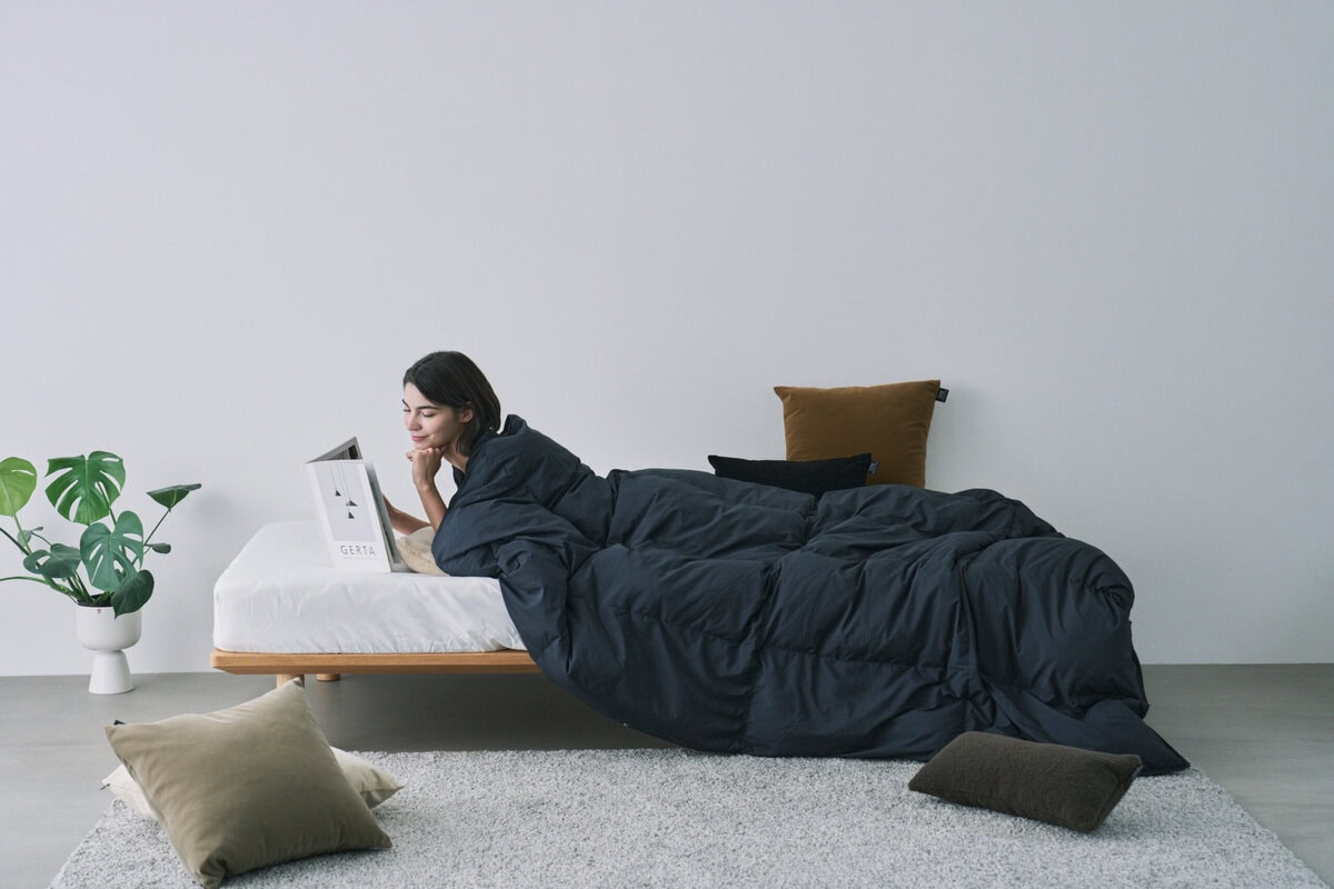 布団としては軽くてあたたかく、羽織ればポンチョやカーディガンのように使える自由な設計。テレビを見ながら、食事をしながら、ゲームをしながら──どんな時間も、ルームダウンに包まれる。