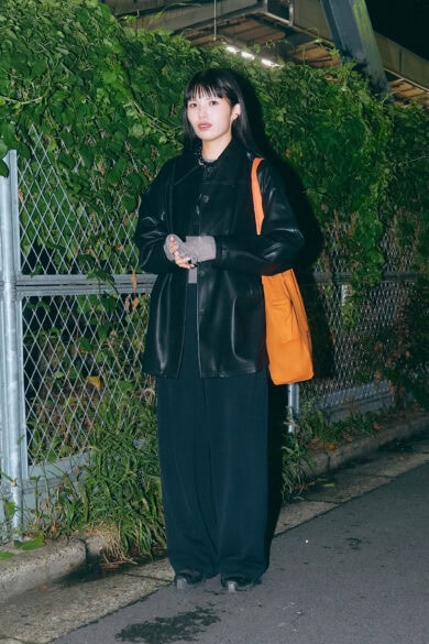 【スナップ】全身モノトーンでも、質感の異なる素材の組み合わせで奥行きを創出。さらに目を引く「挿し色オレンジ」