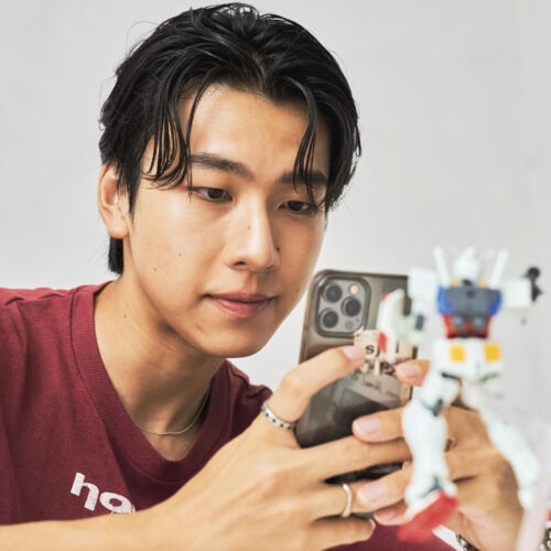 完成したガンプラを撮影するsmartモデル一ノ本くん