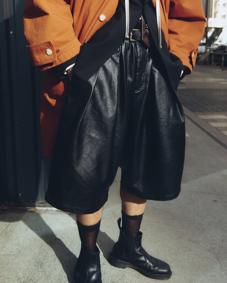 【スナップ】オレンジ色のアウターを際立たせるレザーショーツとドクターマーチン