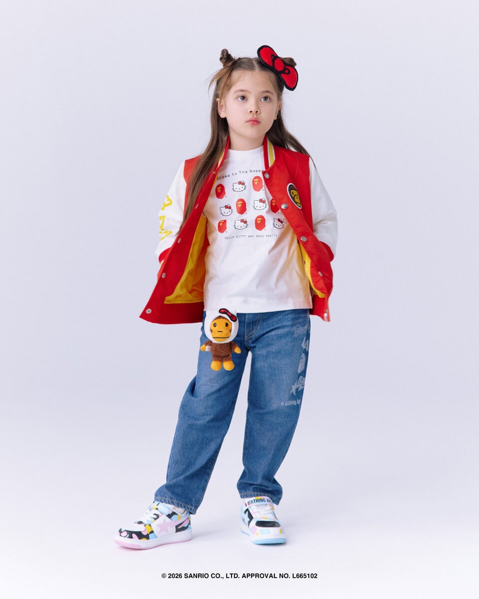 「Welcome to The Bape® World! のグラフィックをベースに、ハローキティがAPE HEADと出会うデザイン。左上にはMAD FACEを配置し、対角線上のハローキティもMAD FACEの表情にすることで、BAPE®ならではの遊び心をプラス。背面には尻尾を配し、後ろ姿にもアクセントを。