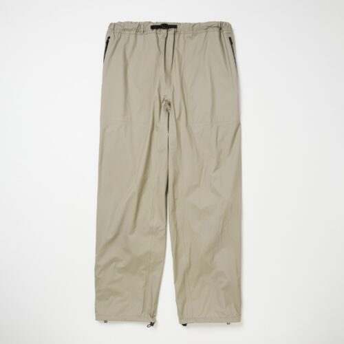 ⻑めのサイドジップを配したレインパンツ。ふくらはぎの裏側にあるドローコードは⾜の動きに合わせて裾が上がってくる現象を防⽌する役割を担う。