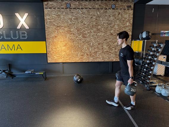 ファーマーズキャリーをする藤田トレーナー