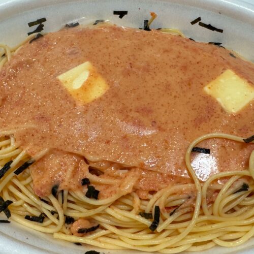 容器の淵ギリギリまで盛り付けられたパスタの山の上にはたっぷりの明太子ソースとバターがトッピング
