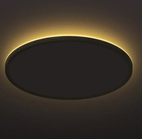 暗い部屋の天井に取り付けられた、薄型の円形シーリングライト。器具の背面から天井に向かって、温かみのあるオレンジ色の間接光が輪のように広がっている。