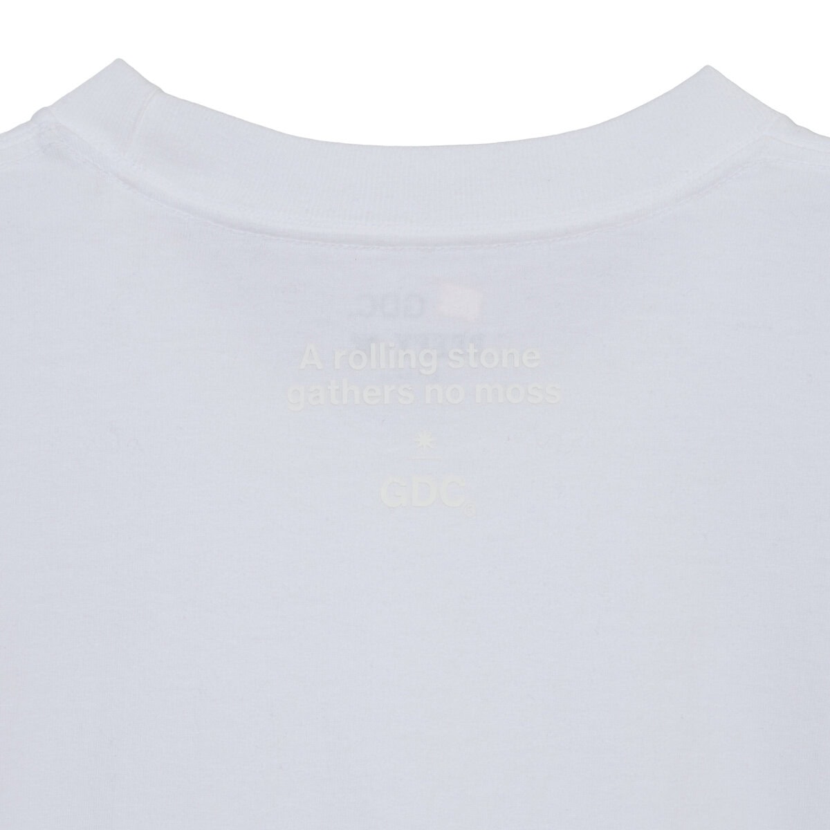 デザインはフロント胸元にGDCロゴ、背面ネックポイントに“A rolling stone gathers no moss”のレターグラフィックを配置。ミニマルな表情の中に、しっかりとメッセージを込めた一枚に。