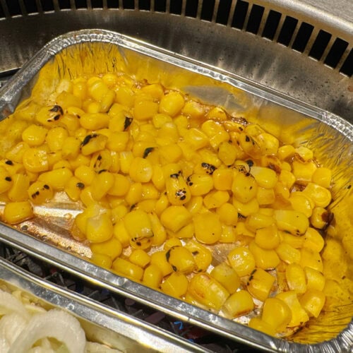 ホイルトレイに入った粒もろこしにバターが溶けて焦がし醤油の香りがフワッと漂い食欲が掻き立てられます