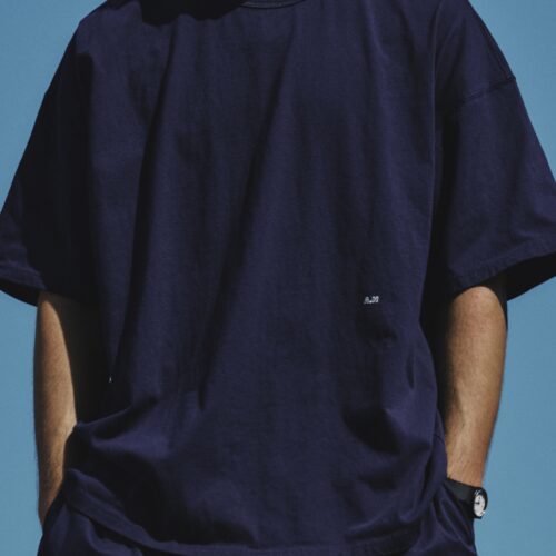 コンビニエンスウェアを代表する無地のアウターTシャツを、「A.H」らしいビッグシルエットで表現した男女兼用モデル。前身頃には「A.H」のロゴを小さく配置。しろとネイビーの2色を用意し、XXL相当のワンサイズで展開している。