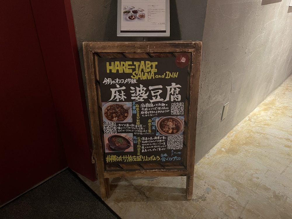 「HARE-TABI SAUNA」エレベーターすぐ横には今月のオススメサ飯を紹介した看板が